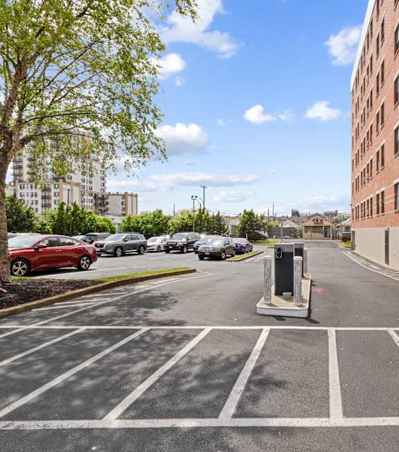 A parking lot with cars and a tall building on the right.
