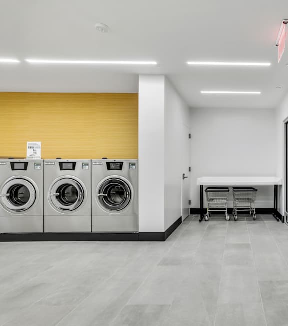 A laundry room with washing machines and a table.