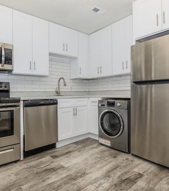 a kitchen with stainless steel appliances and white cabinets