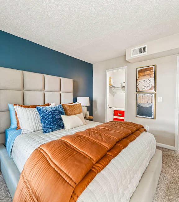 A bedroom with a large bed and a blue wall.