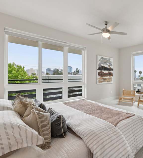 A bedroom with a large bed and two pictures on the wall.