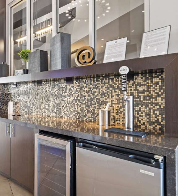 A modern kitchen with a stone backsplash and stainless steel appliances.