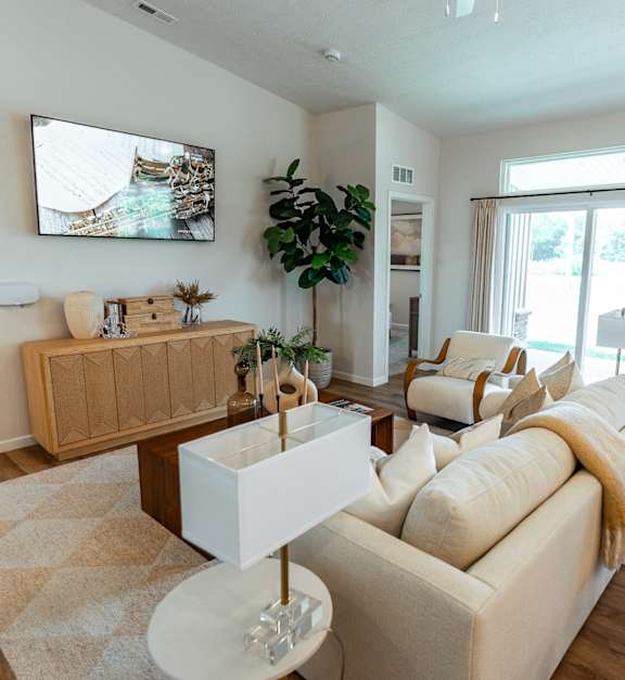 A living room with a white couch and a wooden coffee table.