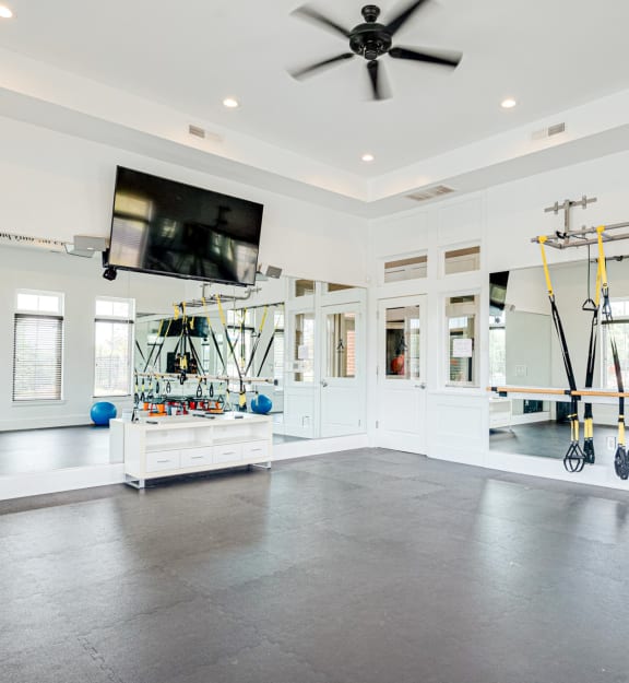 a home gym with weights and a tv on the wall