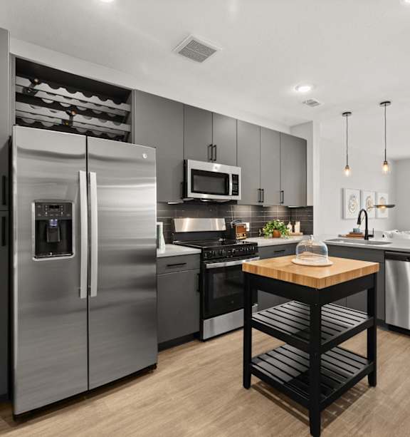 A modern kitchen with stainless steel appliances and a wooden island.