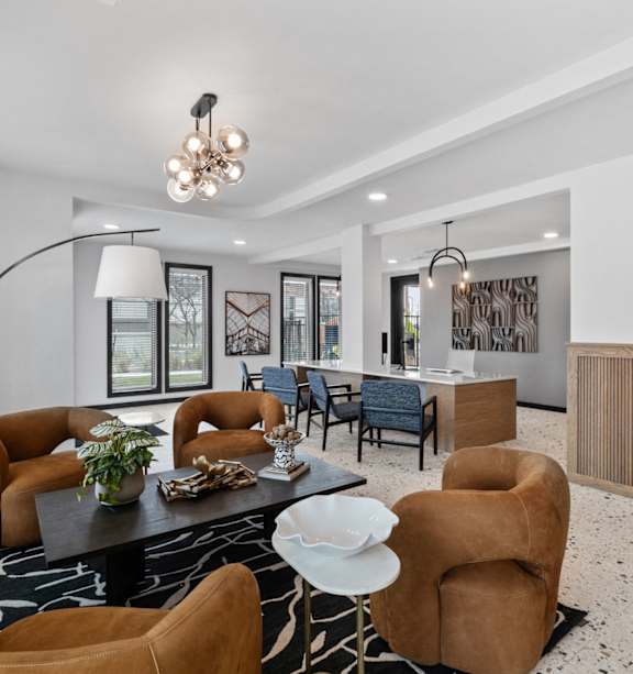 A modern living room with a black and white patterned rug, a coffee table, and a large abstract painting on the wall.