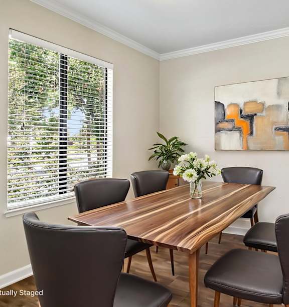 A dining room with a wooden table and chairs.