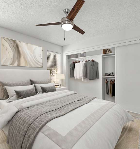 A bedroom with a large bed and a ceiling fan.