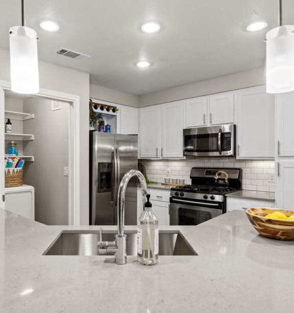 a kitchen with white cabinets and stainless steel appliances  at Nalle Woods of Westlake, Austin, Texas