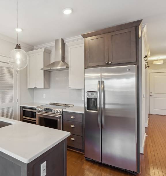 A modern kitchen with a stainless steel refrigerator and a sink with a faucet.