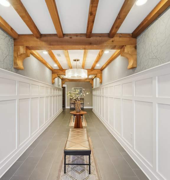 A long hallway with a bench and a light at the end.