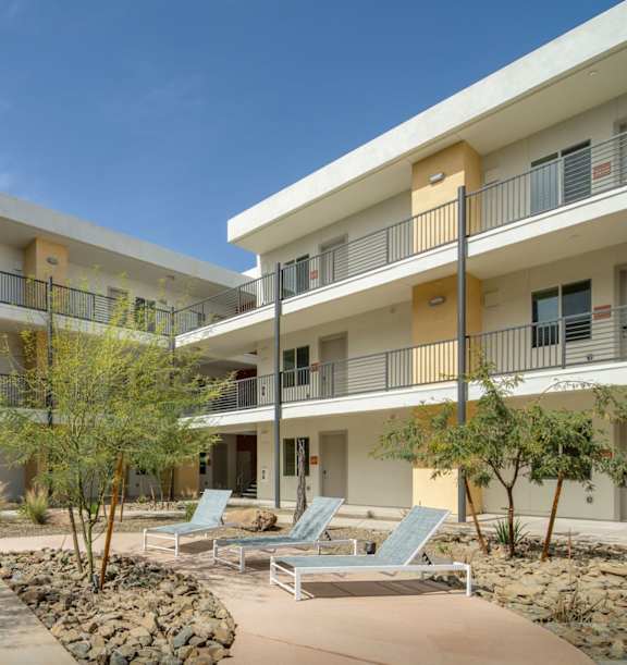 A modern building with orange and white balconies.