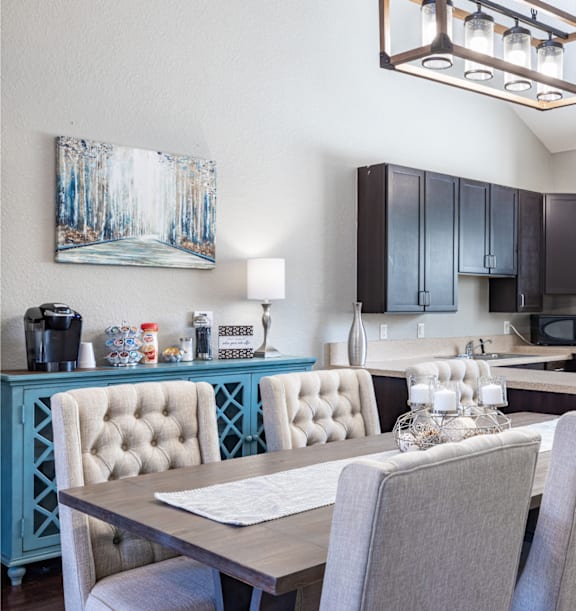 A modern kitchen with a dining table and chairs.