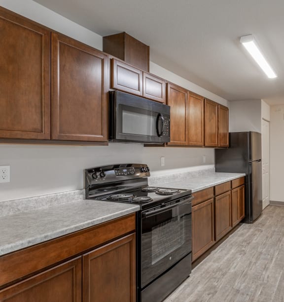 a kitchen with wood cabinets and stainless steel appliances and a sink