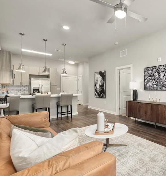 a family sitting on a couch smiling and waving to the camera at The Percy Apartments, Nashville, TN, 37214