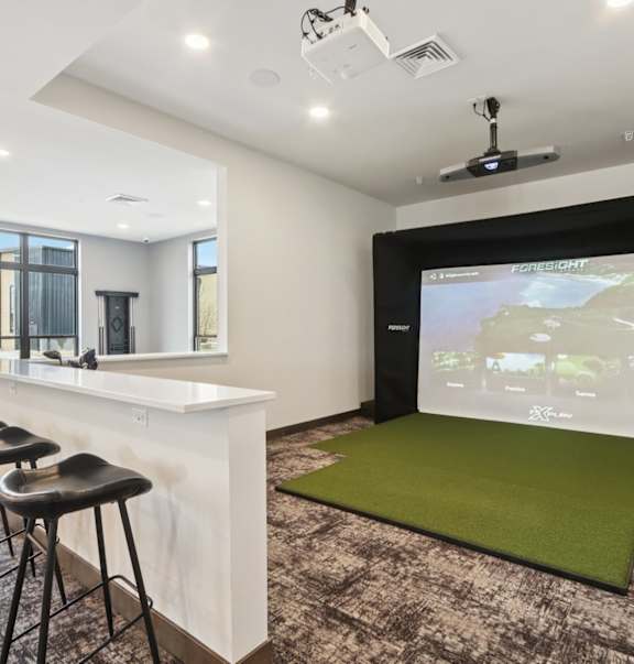 A modern room with a bar and a large screen displaying a map.