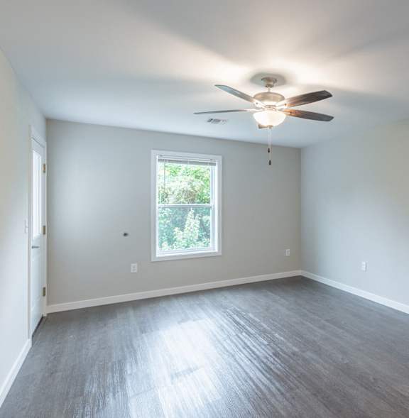 A room with a ceiling fan and a window.