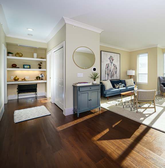A living room with a grey couch and a wooden floor.
