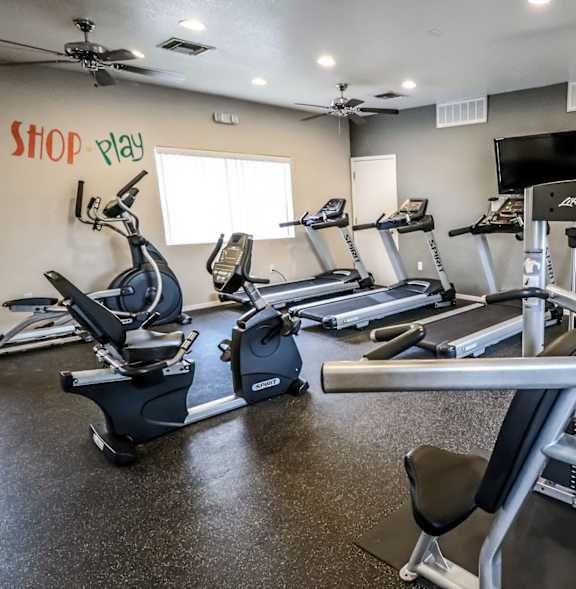 A gym with treadmills, a bench, and a weight machine.