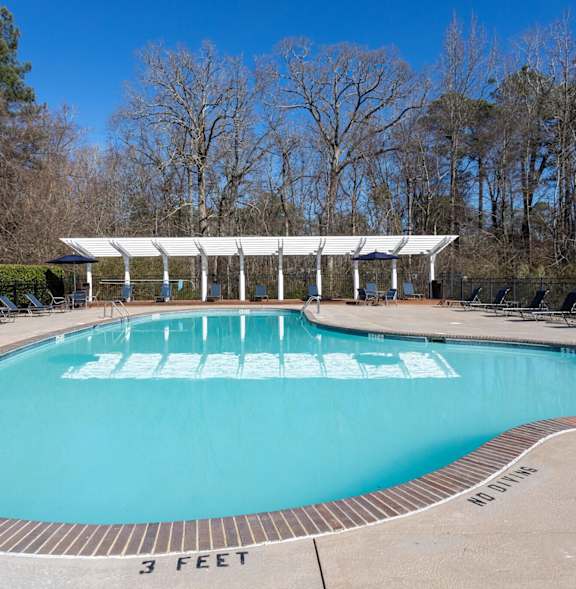 A large outdoor swimming pool with a white canopy over it.