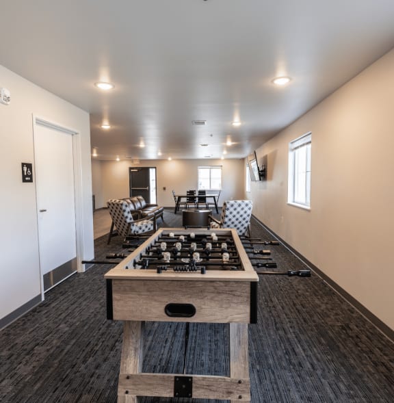an open living room with a kitchen and a game table
