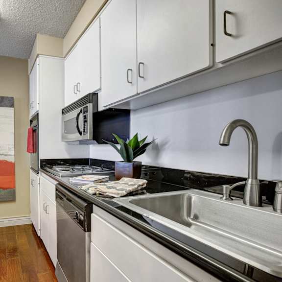 A kitchen with an oven, a microwave, a sink, and a dishwasher at Capitol Towers. 