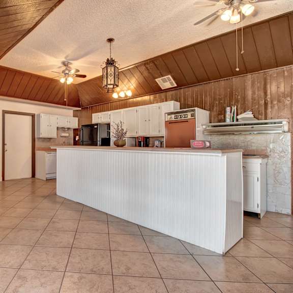 The common area kitchen, with a refrigerator, oven and other appliances, as well as a table and chairs at Avanti Townhomes. 