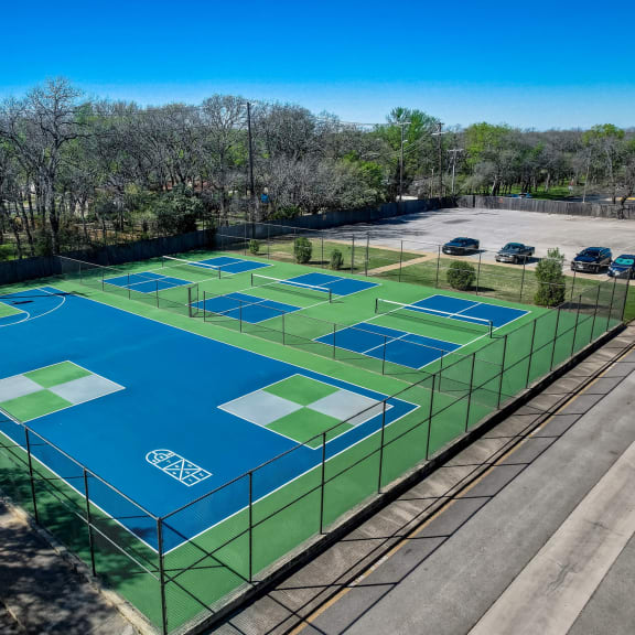 an aerial view of a tennis court on a city street
