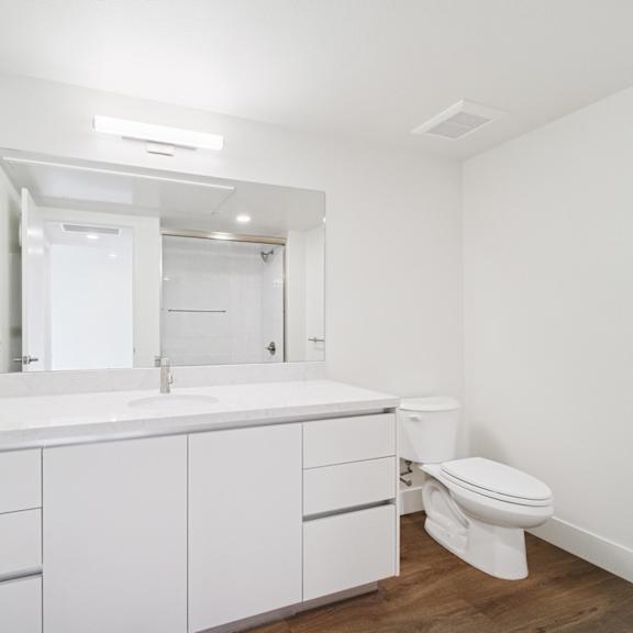 a white bathroom with a toilet and a bath tub