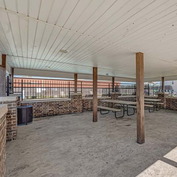 A patio with a table and chairs is surrounded by a brick wall.