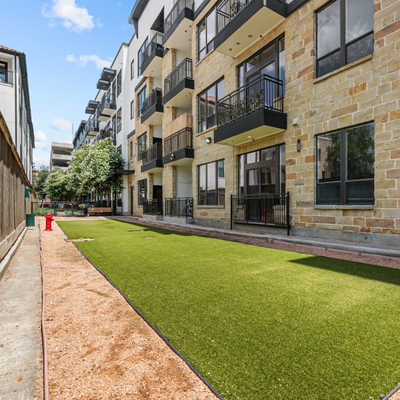 an apartment building with a green lawn in front of it