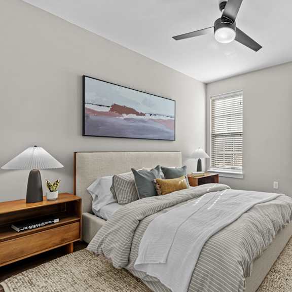 A bedroom with a large bed and a painting on the wall.
