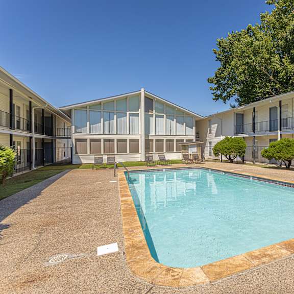 A swimming pool in a courtyard surrounded by apartment buildings.