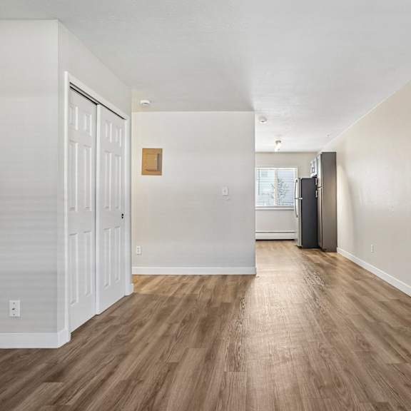 A long hallway with wood floors and white walls.