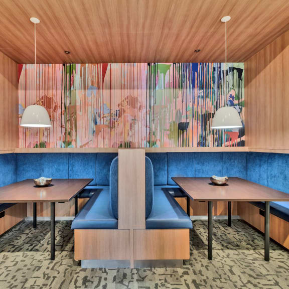 a dining room with wooden walls and blue booths and tables