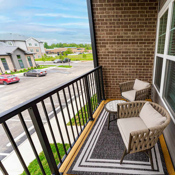 A balcony with a wicker chair and table.