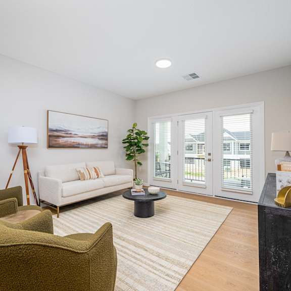 A living room with a white couch, a green armchair, and a coffee table.