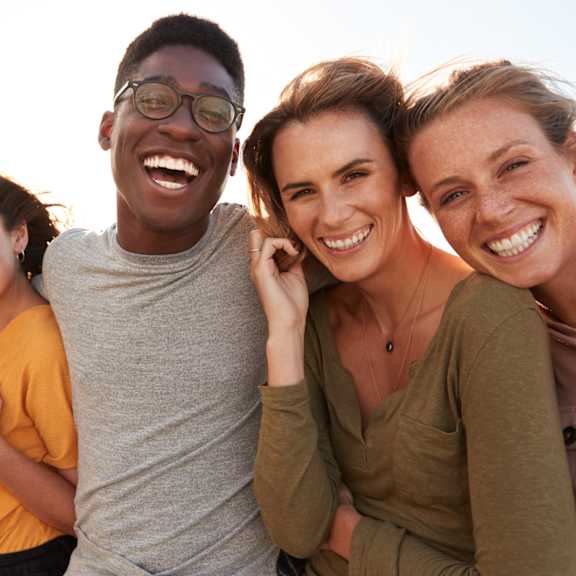 A group of five people are standing together smiling.