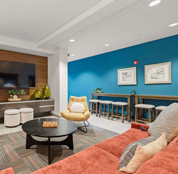 A living room with a grey couch, a black coffee table, and a red couch.