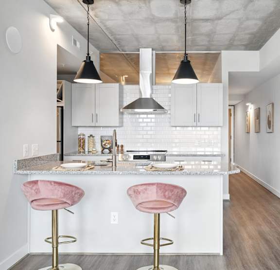 A modern kitchen with a large island and pendant lights.