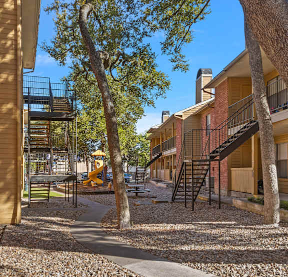 a covered walkway in front of a brick building with a door