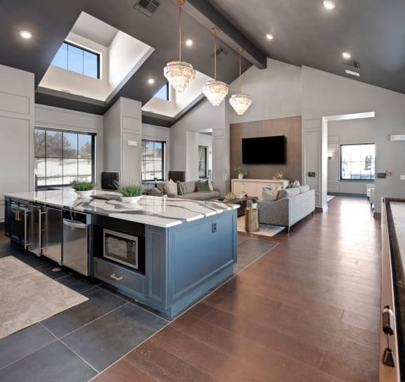 a large kitchen and living room with a large counter top at The Depot Luxury Apartment Homes, Raymore, MO
