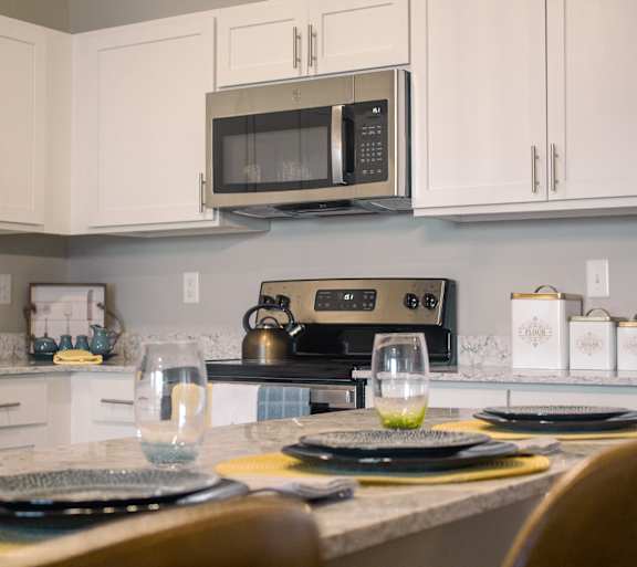 A kitchen with a counter and a microwave above it.