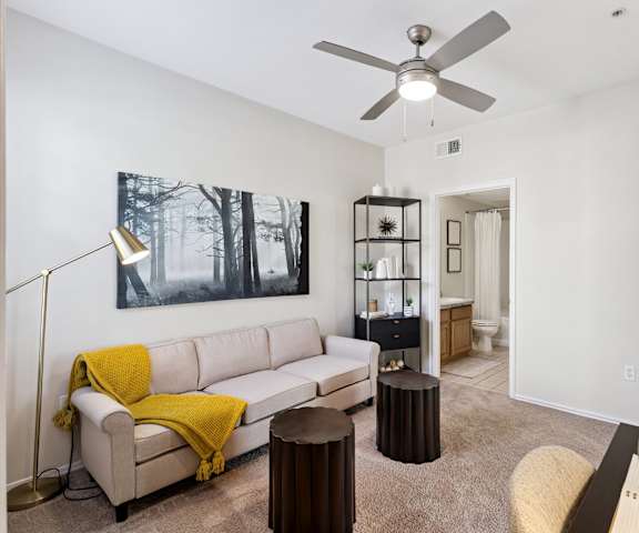 A cozy kitchen with stainless steel appliances, spacious marble countertops, and large wooden cabinets at Quail Landing Apartment Homes. 