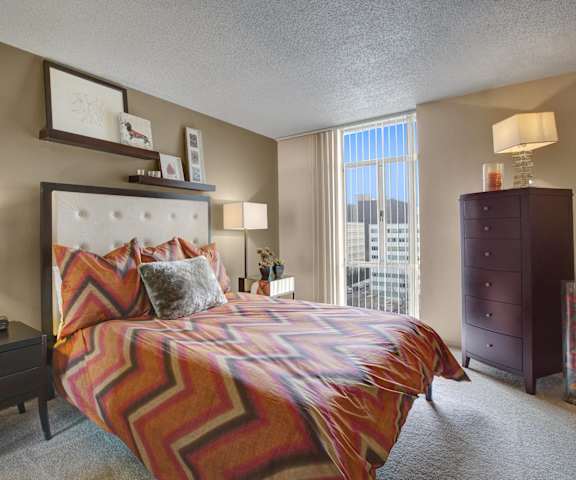 A bedroom with a large bed and a window at Capitol Towers - Towers and Villas.