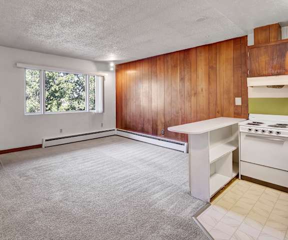 An empty living room with carpeting and the front door at Country Lane Apartments. 
