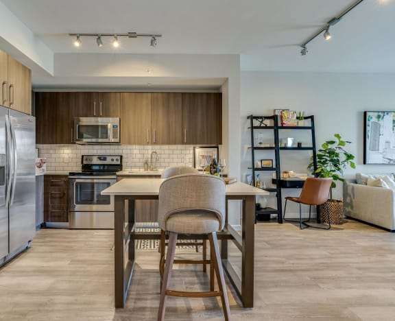 a kitchen with stainless steel appliances and a table with chairs