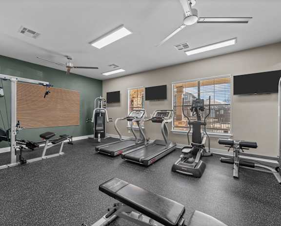 A spacious gym with treadmills, exercise bikes, and other equipment.
