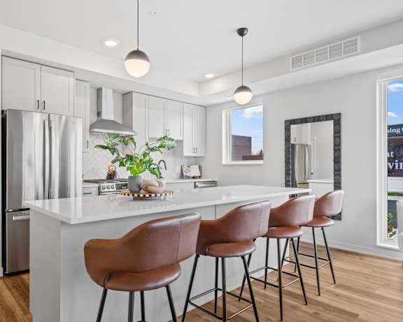 a kitchen with a large island with bar stools