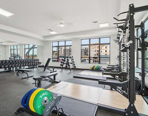 A gym with a variety of equipment including a weight rack and a barbell.